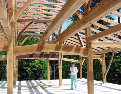 Jean standing in the completed timber frame